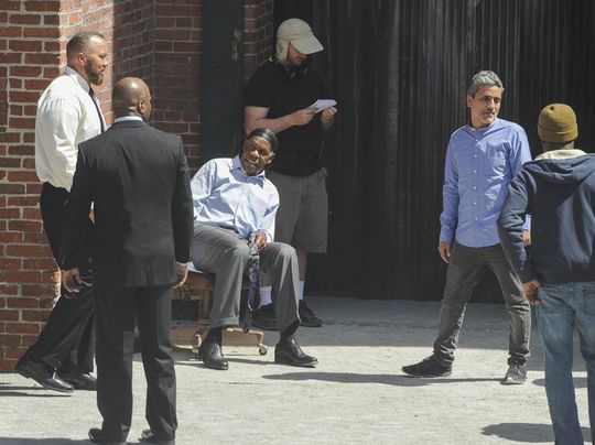 (AMANDA SABGA/ Staff photo) Actor Danny Glover, seated, on the set of "Proud Mary", an upcoming movie being filmed in Lawrence. In the blue Oxford shirt is film diretor Babak Najafi. Local actor Roger Dillingham is to the left of Glover in the white shirt.