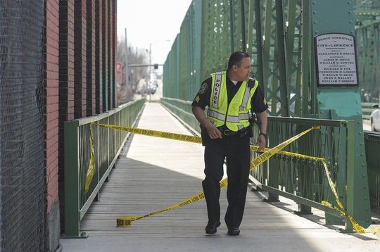 (AMANDA SABGA/ Staff photo) Lawrence Police Sgt. Maurice Aguilar closes off foot traffic on one side of Duck Bridge as filming of the upcoming movie "Proud Mary" gets underway.